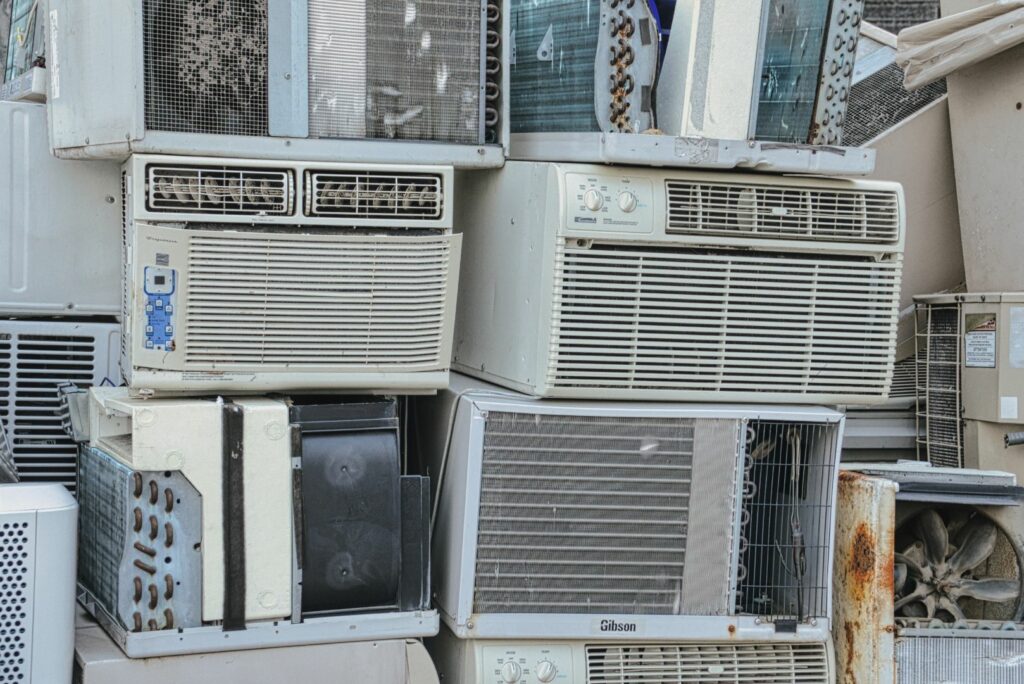 Stacks of old window air conditioning units ready for disposal