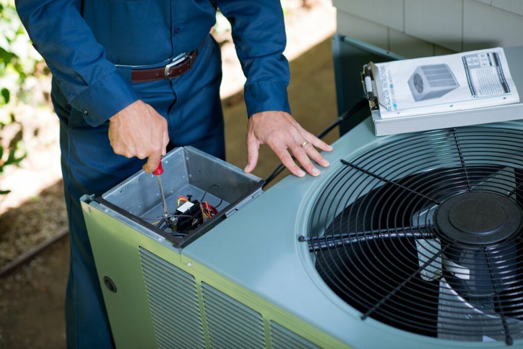 repair man working on air conditioner unit