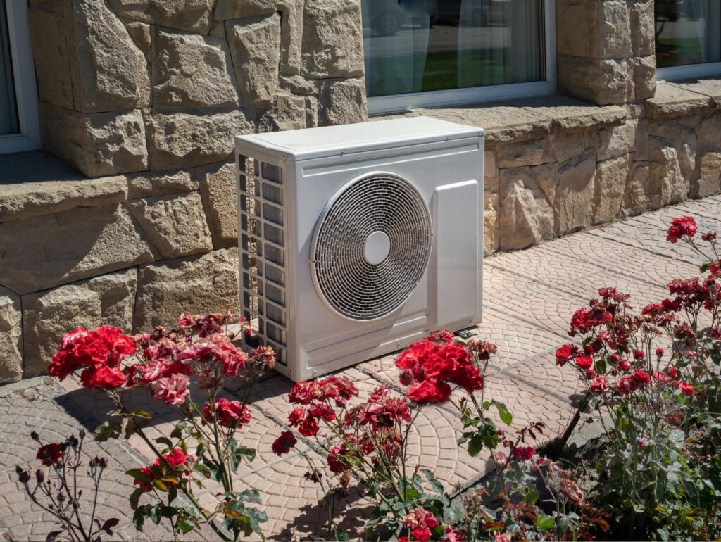 Spring time Air conditioning unit near flowers