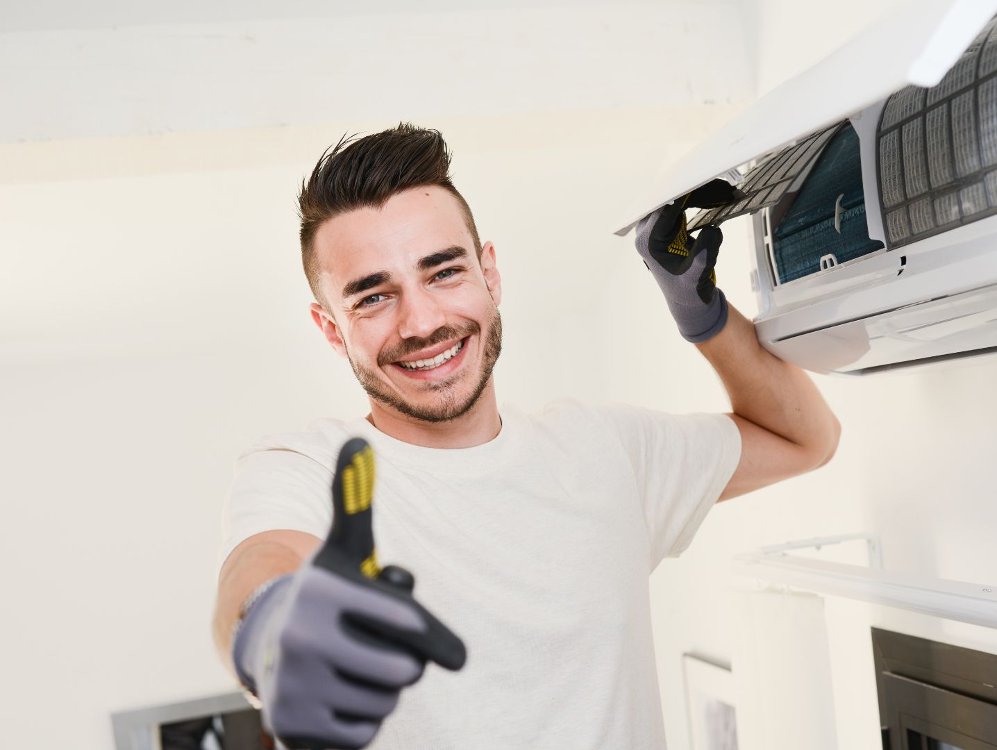 happy man working on wall mounted air conditioner